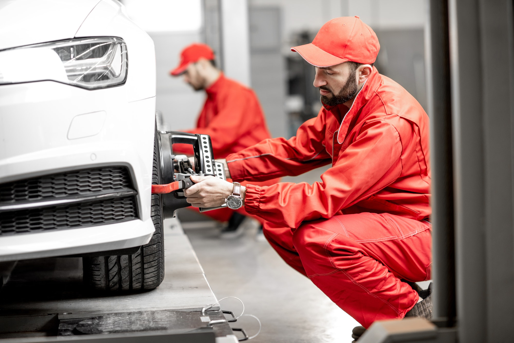 auto-mechanics-making-wheel-alignment-at-the-car-service.jpg